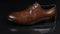 Elegant male shoes with laces stand on a black background with a beautiful reflection. Slider shot.