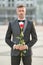 elegant man in tuxedo at romantic occasion. bridegroom with romantic present. romantic man with rose