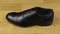 Elegant men`s shoes with laces stand on a wooden floor. The slider shot.