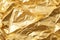 Elegant and mesmerizing gold crumpled foil texture background for captivating designs