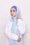 Elegant Muslim woman in white shirt and bright blue hijab. Stylish Iranian girl in Muslim clothing. Isolated portrait of