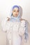 Elegant Muslim woman in white shirt and bright blue hijab. Stylish Iranian girl in Muslim clothing. Isolated portrait of