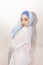 Elegant Muslim woman in white shirt and bright blue hijab. Stylish Iranian girl in Muslim clothing. Isolated portrait of