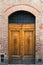 Elegant old double door entrance of brick pink building in Europe. Vintage wooden doorway of ancient stone house. Simple