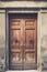 Elegant old double door entrance of building in Europe. Vintage wooden doorway of ancient stone house. Simple brown wood