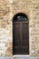 Elegant old double door entrance of building in Europe. Vintage wooden doorway of ancient stone house. Simple brown wood