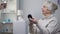 Elegant old woman applying skin powder and refusing medical pills, nursing home