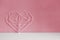 Elegant openwork heart on a pastel pink background. Minimalism. Concept Symbol of love and Valentine`s Day. Home Decor