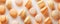 Elegant, pastel colored orange and yellow macaroons on white surface. Sweet food background. Gourmet cookies. Generative AI