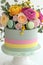 Elegant Pastel-layered Cake Adorned with Roses and Macarons for Celebratory Occasions