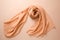 A elegant peach fuzz color silk satin scarf on soft minimal background. Modern trendy tone hue shade