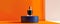 Elegant perfume bottle on a minimalist blue podium against an orange background