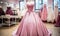 Elegant pink strapless ball gown on mannequin in a bridal boutique with various wedding dresses in the background, romantic bridal