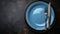 An elegant plate with knife and fork arranged tastefully on a sophisticated dark background, Ai Generated