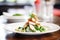 elegant plating of chicken caesar salad with a sprig of rosemary