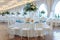 Elegant reception white pavilion with round tables covered in blue