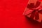 Elegant red gift box with silk ribbon bow on crimson velveteen background. Trendy Christmas New Years Valentine card poster
