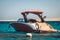 Elegant Red Luxury motor boat on the background of the azure blue sea and a strip of sandy mountains in the background