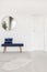 Elegant round mirror above velvet bench in white waiting room interior