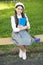 Elegant schoolgirl child girl with book in park, books from library concept