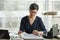 Elegant senior businesswoman working with papers at desk in office