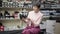 Elegant senior woman sitting in shoe store admiring black high-heels. Portrait of positive Caucasian retiree buying new