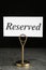 Elegant sign RESERVED on grey surface. Table setting element