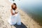 Elegant smiling girl bride in a white dress on a sandy river beach