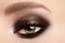 Elegant smoky make-up on female eyes. Beauty, cosmetics and makeup. Dark brown eyeshadow make-up, glamour evening style