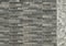 Elegant stone cladding wall made of gray granite panels with different shades and shapes.