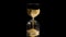 Elegant and stylish bronze transparent sandglass with trickling golden round particles. Stock footage. Sandglass