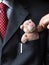 The elegant stylish businessman keeping cute teddy bear in a his breast suit pocket. Hand shaking teddy bear\'s paw. Formal n