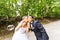 Elegant stylish groom and happy gorgeous bride have fun with bubble blower outdoors in park