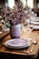 Elegant table with porcelain tableware, crystal glasses, vases and flowers in lavender tones