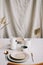 Elegant table setting for fine dining with cutlery, plates, cups on a linen tablecloth. Home decor rustic table setting
