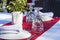 Elegant table setting with fork, knife, wine glass, white plate and red napkin in restaurant . Nice dining table set with arranged