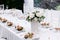 Elegant table setting. White tablecloth, appetizers, vase with delicate bouquet