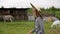 Elegant teen girl in hat and dress walking in rural farm
