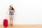 Elegant traveler woman standing on wooden floor