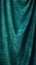 Elegant velvet fabric background. Emerald green velor flows in waves and folds, vertical format