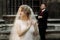 elegant wedding couple posing in old courtyard in european street. luxury bride under veil and groom standing. romantic sensual m