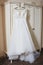 elegant wedding dress  embroidered with beads hanging on a vintage wardrobe. details  preparation for the wedding