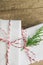 Elegant White Gift Boxes Tied with Red Ribbon Green Juniper Twig Stacked on Wood Tabletop Background. Christmas New Years Presents