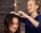 Elegant woman in beauty saloon. Hairdresser does coiffure in the form of big curl. Concept wedding hairstyle