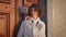 Elegant woman posing wooden door at evening sunlight closeup. Curly-haired lady