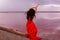 Elegant Woman In Red Silky Dress Walking By A Salt fantastic Lake At Sunset.