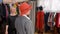 Elegant woman smiling and posing while fitting red hat in fashion showroom. Stylish mature woman choosing elegant hat in