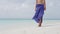 Elegant woman walking on pristine beach