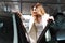 Elegant woman watching car at a dealer center