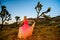 Elegant woman, wearing a fancy dress and standing like a fairy among the Joshua Trees at sunset